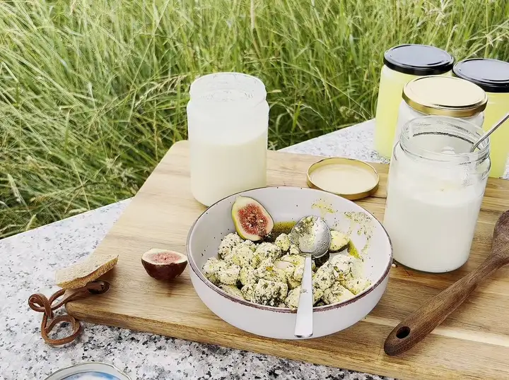 Frischkäsewürfel in Kräuter-Knoblauch-Öl in einem Weckglas